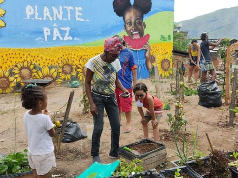 Dona Lúcia com as crianças na Horta Comunitária Raízes